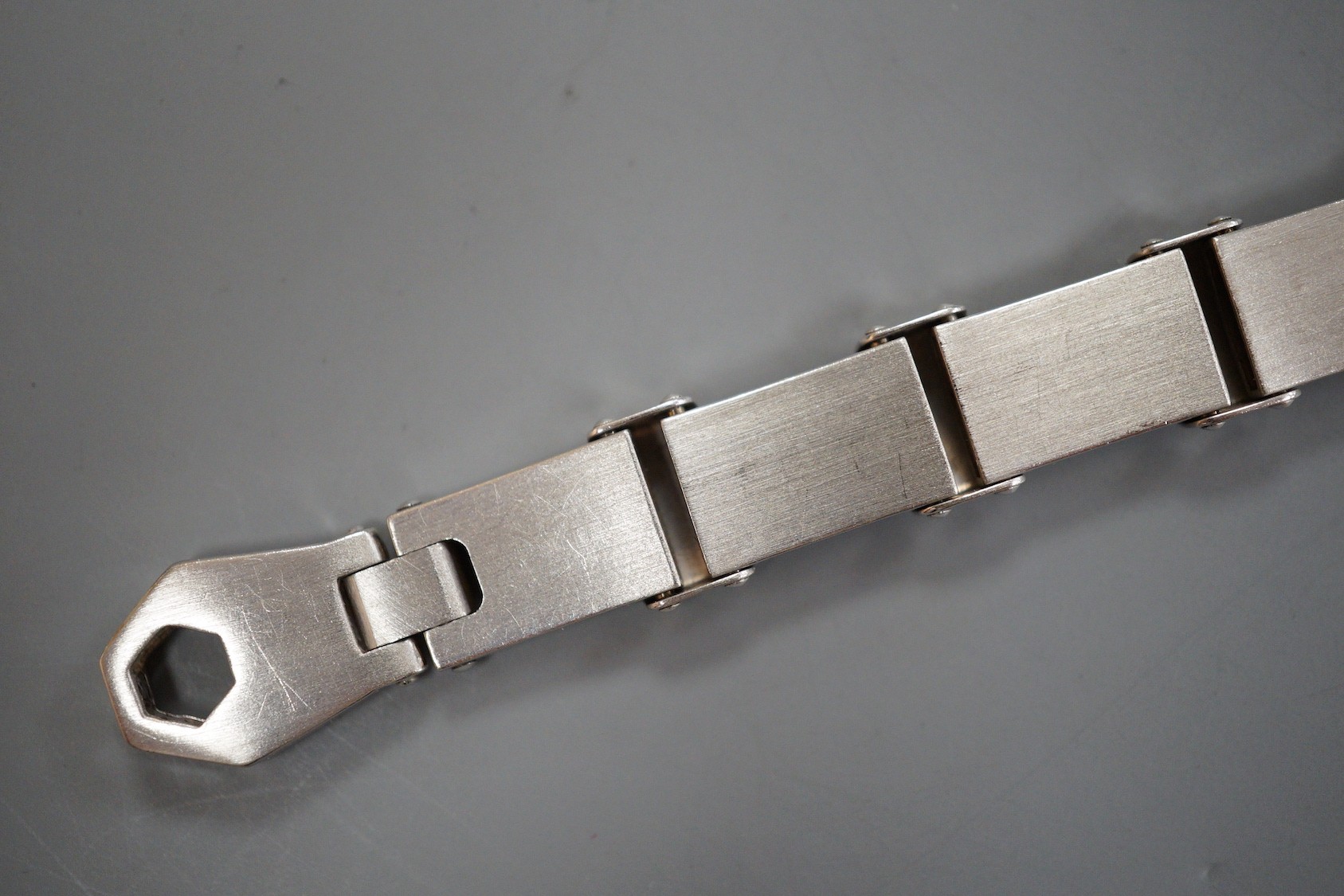 A cased modern white metal (tests as 18ct) bracelet with matt finish alternating links, overall 21.5cm, 34.7 grams, retailed by Musson.